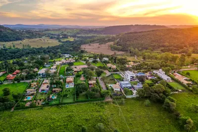 Vista aérea do condomínio com casas e piscinas ao entardecer
