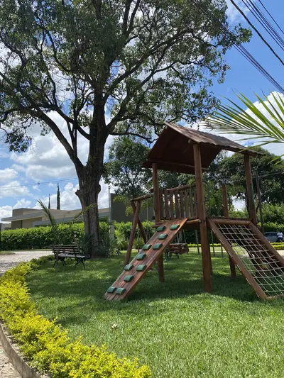 Área de lazer infantil em meio a árvores grandes